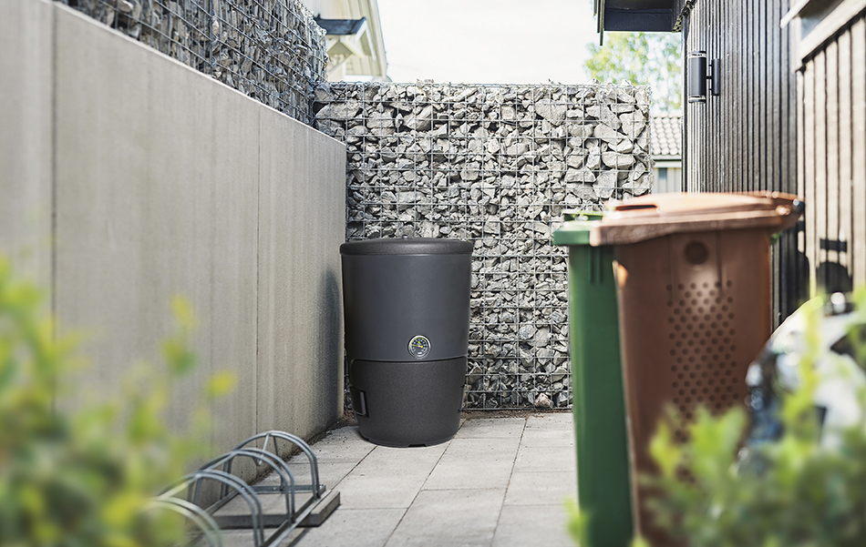 Kekkilä Kotikompostori kodin pihan jätteiden keräyspisteellä. Kompostori sopii kotitalousjätteen kompostointiin ja vastaa uuden jätelain vaatimuksia.
