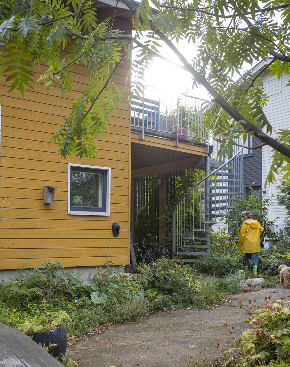 Keltaisen omakotitalon piha on kompakti, mutta luonnonläheinen omavarainen puutarha